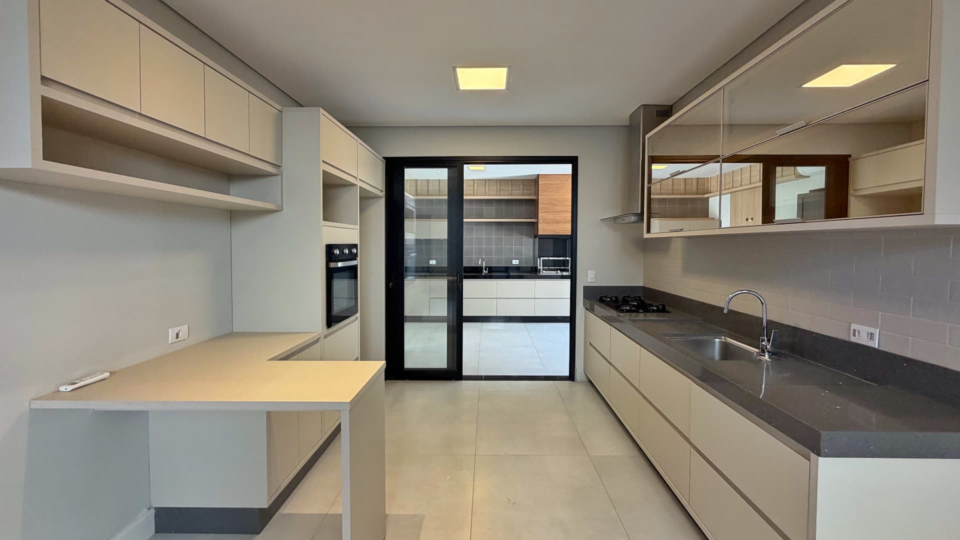 Cozinha planejada com forno embutido e área de serviço