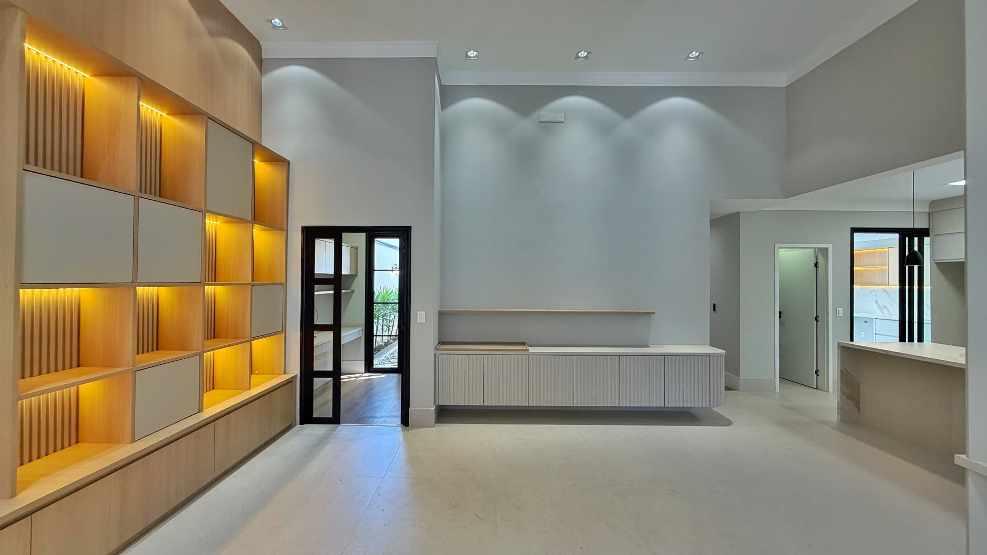 Sala integrada à cozinha com marcenaria e porta de vidro