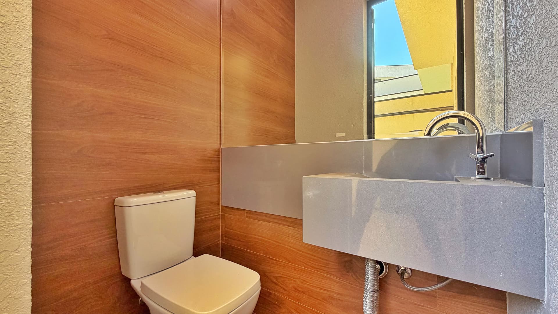Lavabo externo com revestimento amadeirado e cuba esculpida