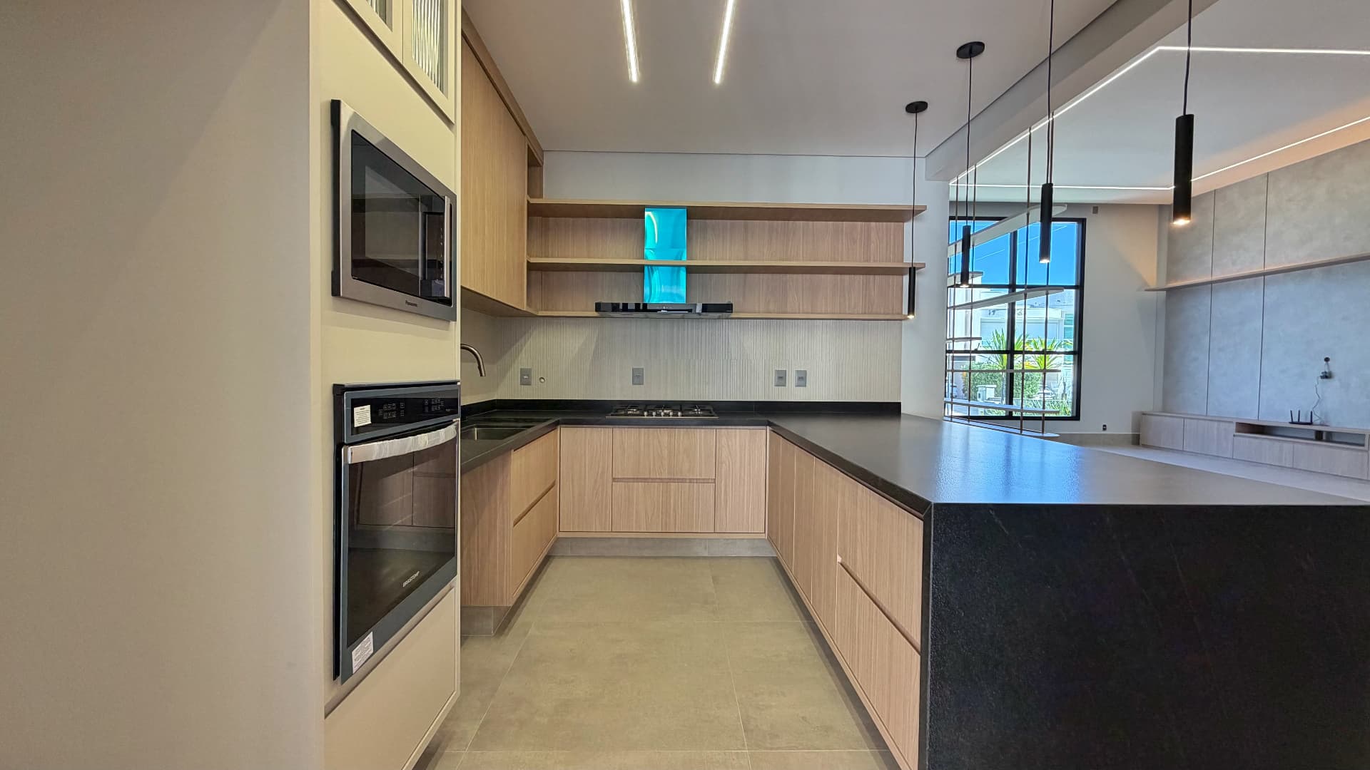 Cozinha em U com cooktop, coifa e prateleiras de madeira