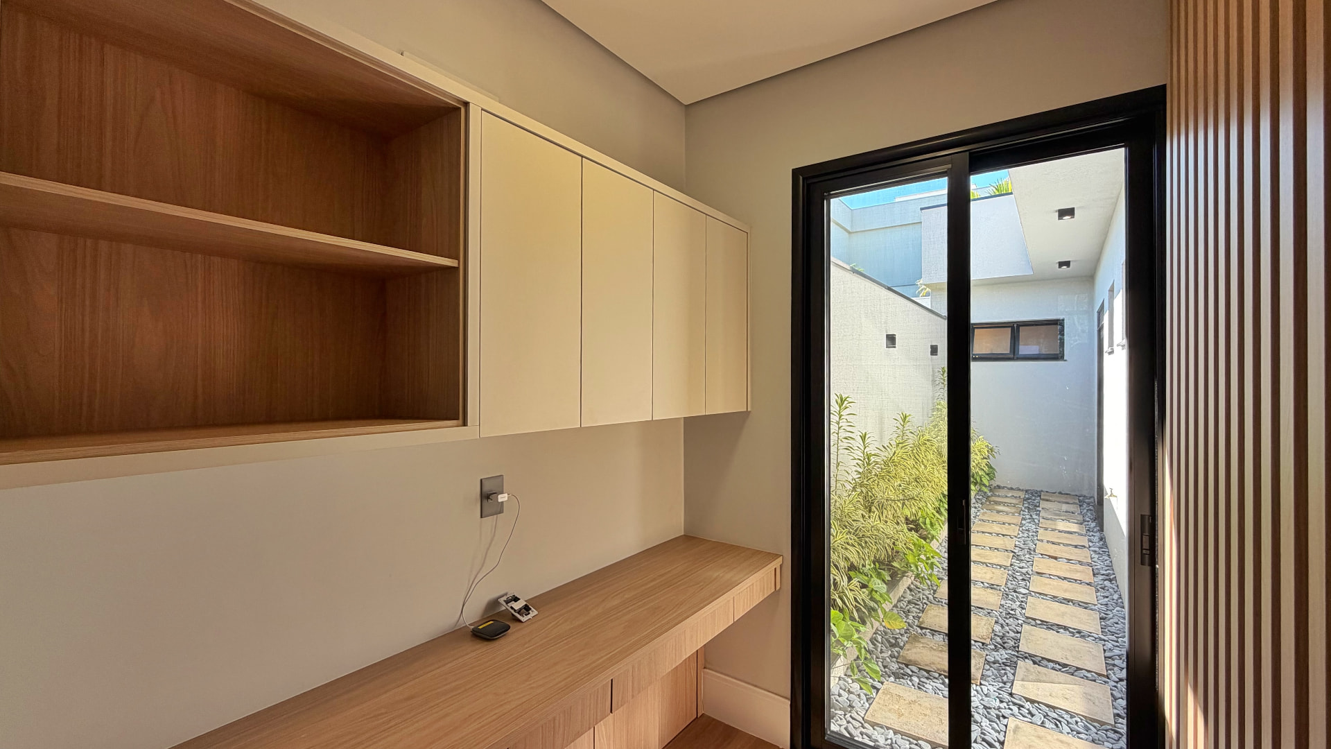 Home office com marcenaria planejada e vista para o jardim interno