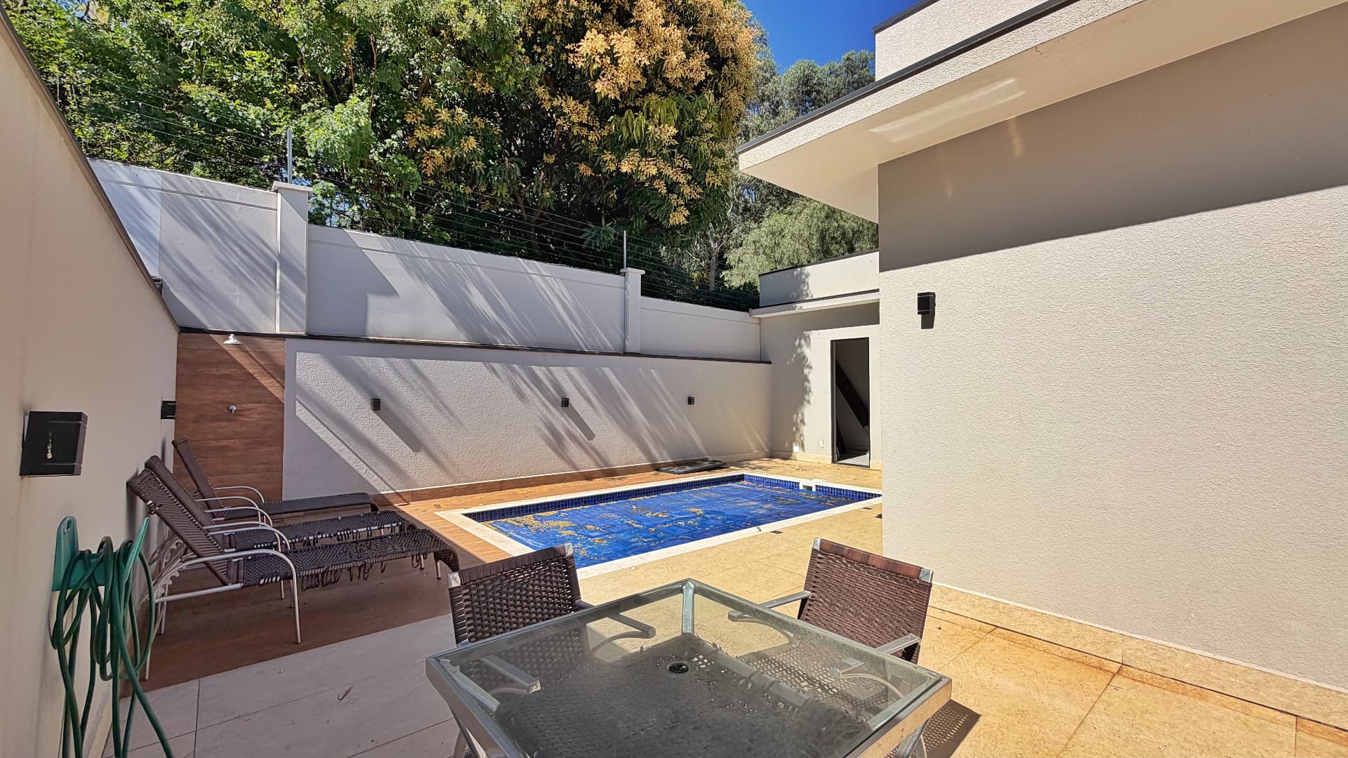 Área da piscina com espreguiçadeiras e ducha externa